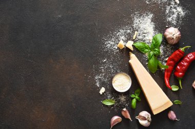 Beton arka planda fesleğen, sarımsak ve biberli parmesan peyniri. Sos için malzemeler, üst görünüm.