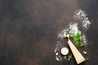 Beton arka planda fesleğenli parmesan peyniri. Sos için malzemeler, üst görünüm.