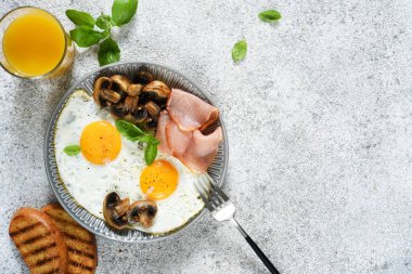 İngiliz kahvaltısı. Mantarlı sahanda yumurta ve kahvaltıda bir bardak portakal suyu ile jambon. Günaydın..