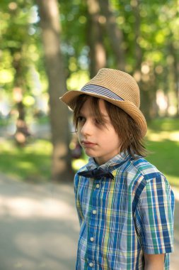 Okul çocuğu bir şapka ve kravat - kelebek park üzerinde gider. O ne o üzgün ya da ciddi