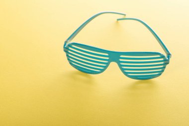 Bir şerit dekoratif güneş gözlüğü üzerinde sarı bir arka plan yansıması ile yalan.