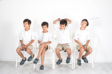 Çocuk bir sandalyede oturuyor ve onun çevirmek için bekliyor. O çok sabırsız, acı çekiyor, ama o bir kağıt uçak ile oynayarak deli.