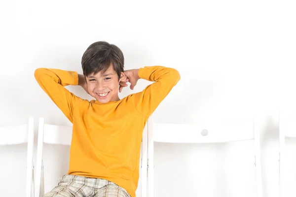 Alegre Chico Una Camisa Amarilla Sentado Una Silla Riendo —  Fotos de Stock