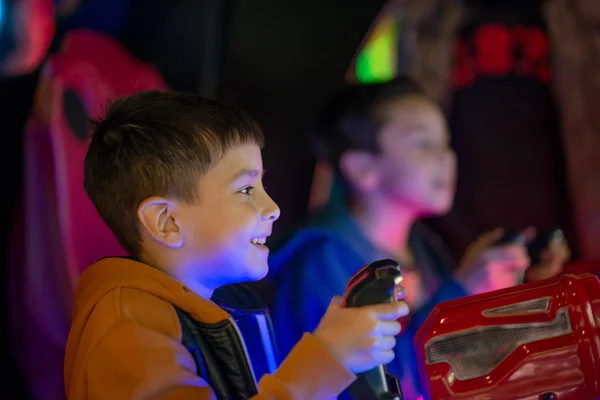 The children emotionally play on gaming machines in entertainment center