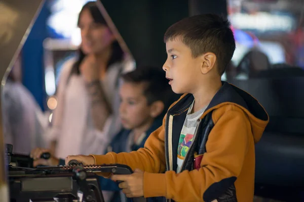 The children emotionally play on gaming machines in entertainment center
