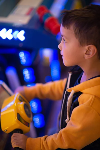 The child emotionally plays on gaming machines in entertainment center