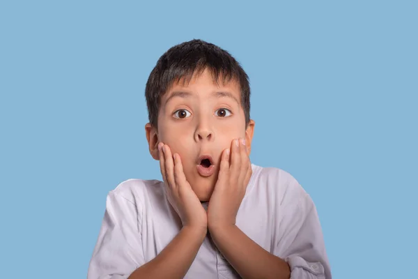 Маленький Хлопчик Білій Сорочці Емоційно Здивований Чимось Синьому Фоні Студії — стокове фото