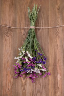  Kuru çiçekler limonium çok renkli, jüt halat ile bağlı asmak bir kahverengi ahşap duvar veya çit