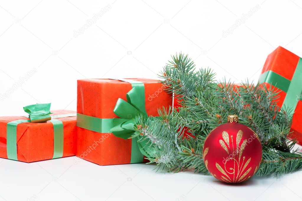 On the white table is a decorative ball for the Christmas tree, Christmas tree twigs and gift boxes for Christmas.