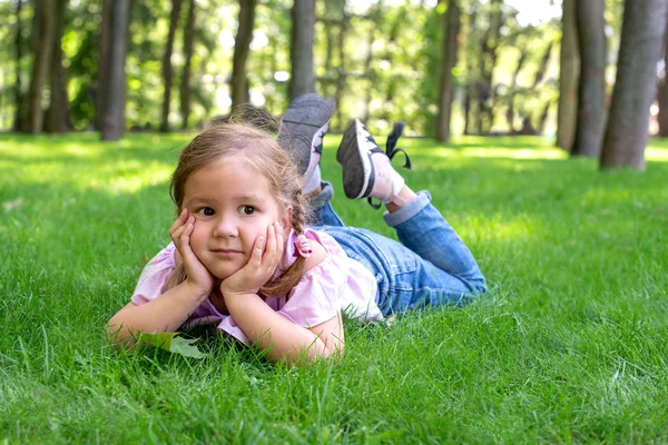 Het Kleine Meisje Ligt Het Groene Gras Het Park Dromerig — Stockfoto