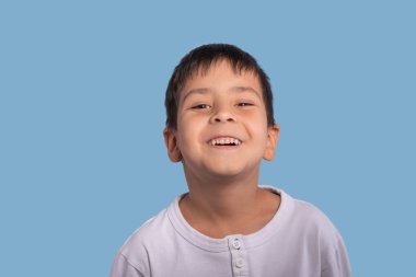 Duygusal portre Studio mavi bir arka plan üzerinde beyaz gömlek giymiş boy gülümseyerek.