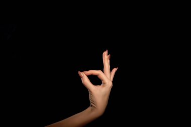 Kimliği belirsiz bir kadın eli parmak bir jesti her şeyin gösterilen stüdyo çekim iyi veya Ok, siyah bir arka plan