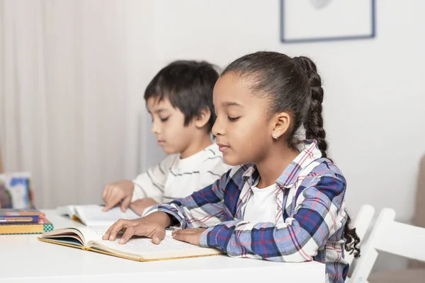 子供たちは 男の子と Mullata の女の子 テーブルに座るし 書籍や屋内で教科書を読む — ストック写真