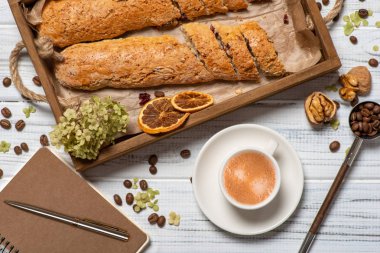 Bir fincan kahve ve defter kalem ile stüdyo atış bir ahşap tepsi ev yapımı kek