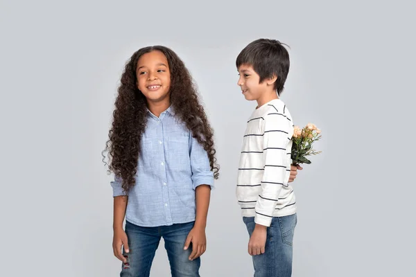 Студійний Знімок Хлопчика Дарує Квіти Дівчині Ізольований — стокове фото