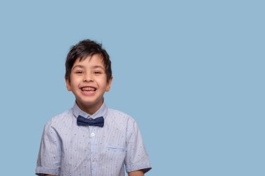 Bir gülen çocuk stüdyo çekim yay ile mavi T-shirt giyiyor