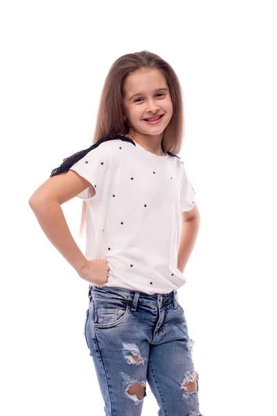 Foto de estudio de una niña sonriente con pantalones vaqueros y blanco bl —  Fotos de Stock