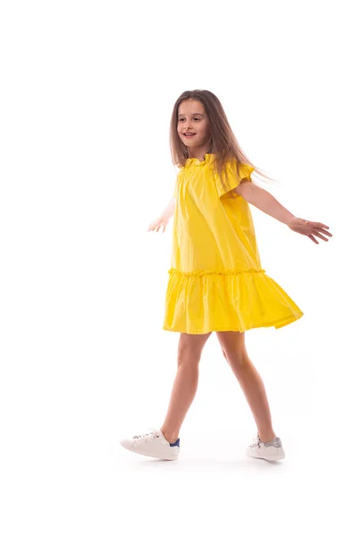 Plan studio d'une petite fille souriante portant une robe jaune sur — Photo