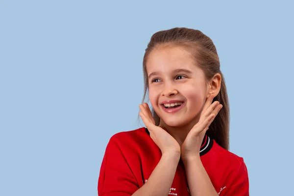 Estúdio tiro de uma menina sorridente vestindo camisa vermelha em um bl — Fotografia de Stock