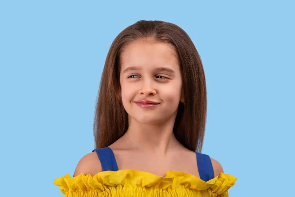 Студийный снимок молодой девушки в жёлтом сарафане на синем — стоковое фото