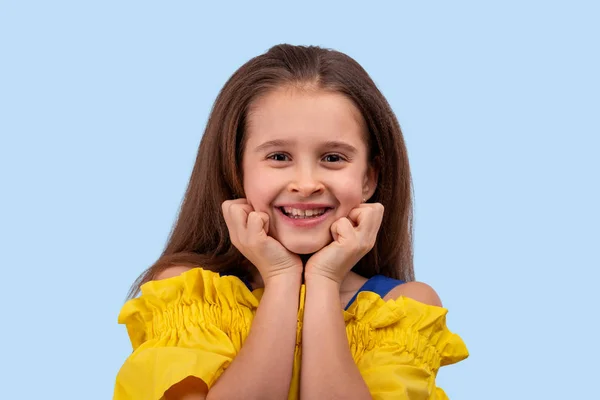 Estúdio tiro de uma menina vestida sundress amarelo em um azul — Fotografia de Stock