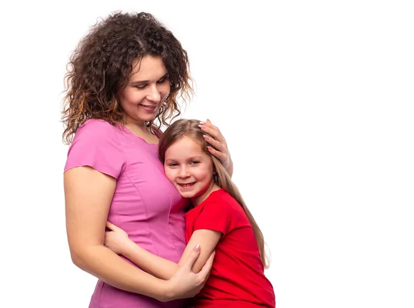 Розрізана дівчинка посміхається, обнімаючи маму щільно — стокове фото