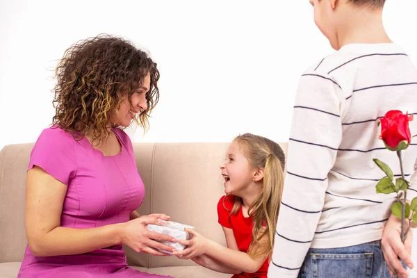 Shot de una madre y sus dos hijos sosteniendo regalo y flor fo — Foto de Stock