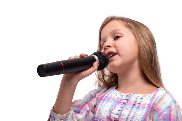 Elinde bir mikrofon ile küçük kız bir şarkı söylüyor, izole — Stok fotoğraf