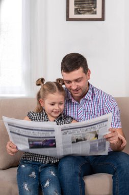 Bir kız ve baba evde kanepede oturan bir stüdyo çekim