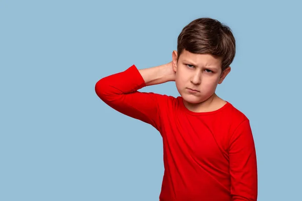 Studio shot van een serieuze jongen denken over iets krabben — Stockfoto