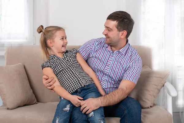 Студійний знімок дочки і тата весело сидить на дивані — стокове фото