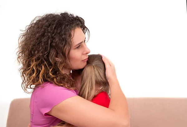 Una joven madre calma a su pequeña hija. La chica está llorando y... — Foto de Stock