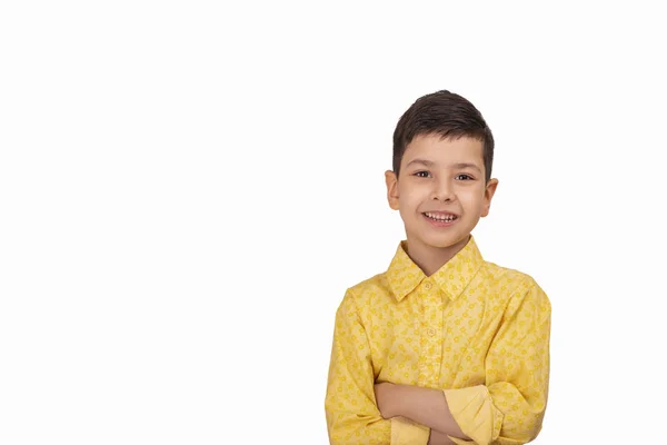 Retrato de menino sorrindo vestindo camisa amarela com braço cros — Fotografia de Stock