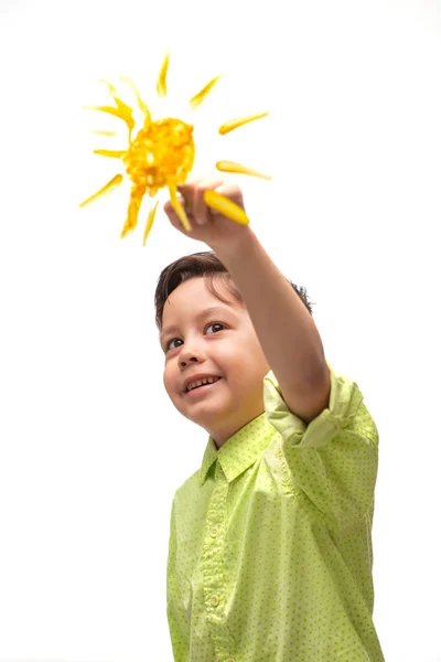 Kleine jongen dragen groen shirt enthousiast schildert zon en — Stockfoto