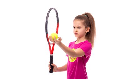 Pembe t-shirt giyen küçük ciddi bir kız tenis ile duruyor
