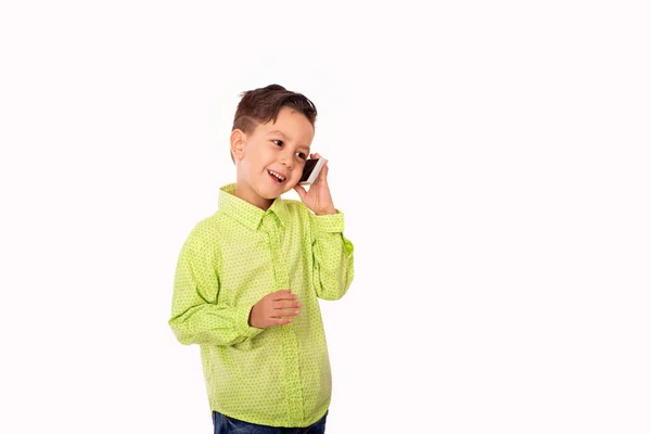 Un niño sonriente vistiendo camisa verde hablando por teléfono, yo —  Fotos de Stock