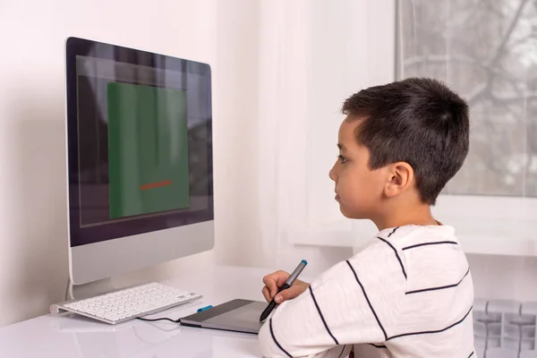 Schoolboy desenho em um computador usando um tablet — Fotografia de Stock