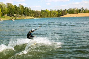 Tulumlu bir wakeboarder, sıçrama tahtasında süzülüyor.