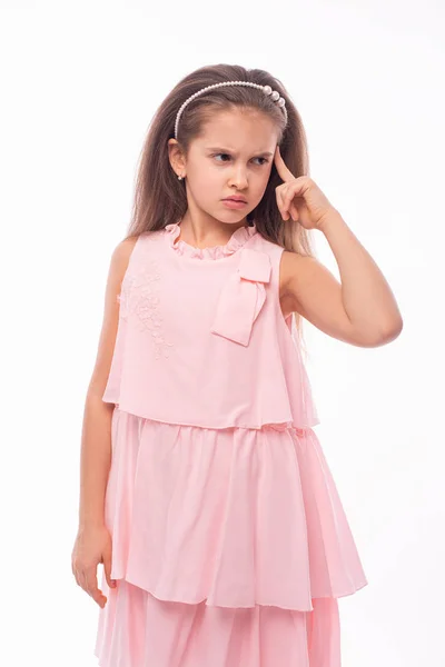 Mała dziewczynka ubrana w różą sukienkę myśli o czymś SE — Zdjęcie stockowe