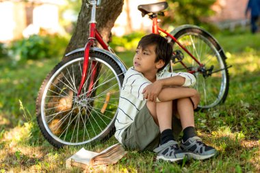 Çocuk bahçede çim üzerinde oturur ve ih hakkında rüyalar