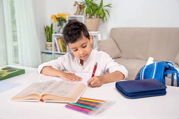 Midja upp porträtt av en allvarlig skolpojke lokalisering på bordet på — Stockfoto