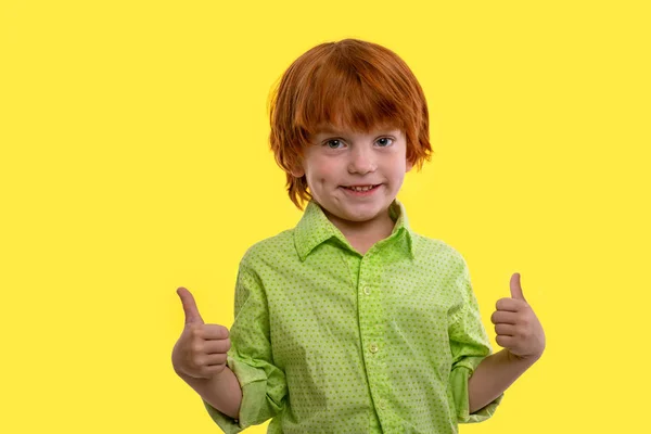 Een jonge jongen rood-haar dragen groen shirt civing u een APU — Stockfoto