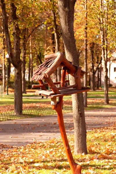 Holzvogelfutterhäuschen im Park im Herbst. — Stockfoto