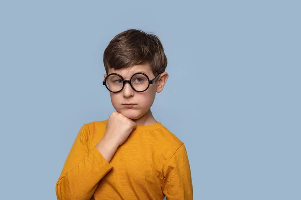 Taille up portret van een jonge jongen in ronde glazen denken over — Stockfoto
