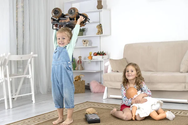 Malé děti sedí na podlaze na koberci v pokoji doma a — Stock fotografie