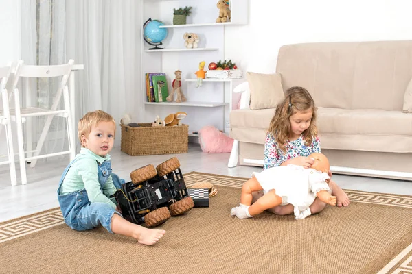 Malé děti sedí na podlaze na koberci v pokoji doma a — Stock fotografie