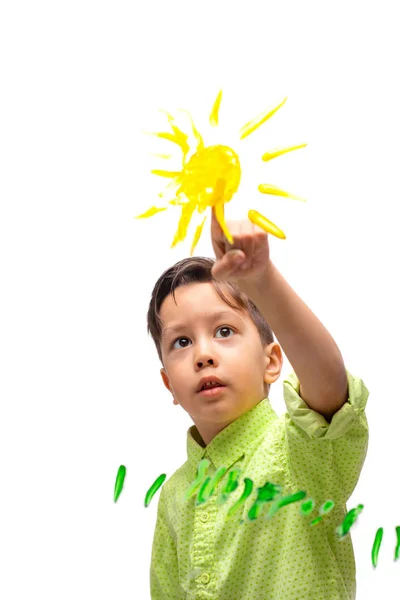 Kleine jongen dragen groen shirt enthousiast schildert zon en — Stockfoto