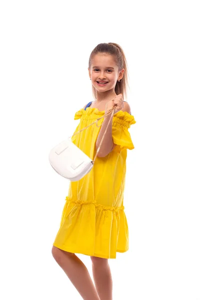 Studio lövés egy kis mosolygó lány táska viselt sárga nap — Stock Fotó