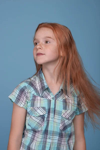 Σφηνάκι από ένα μικρό αστείο κοκκινομάλλα κορίτσι εναντίον μπλε φόντο — Φωτογραφία Αρχείου