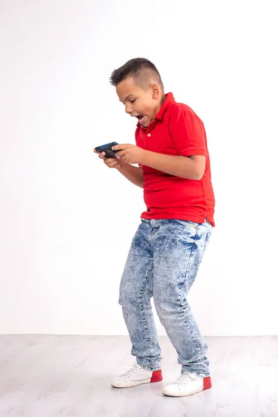 Постріл молодого хлопчика стоїть з телефоном і емоційно простий — стокове фото